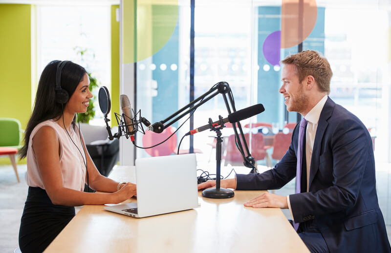 Young woman interviewing a guest in a studio for a podcast